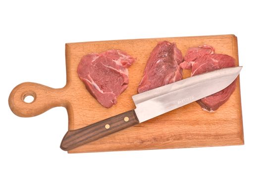 Slices of the meat on the board with knife on the kitchen