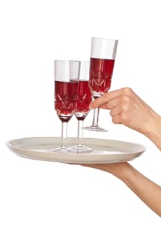 waiter carrying glasses with red wine on the party