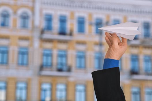 businessman in a business suit throwing white paper plane