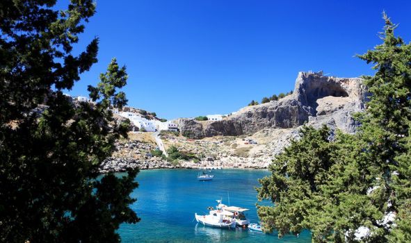 Beautiful St Pauls Bay shadowed by the temple and castle ruins at Lindos 