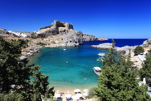 Beautiful St Pauls Bay shadowed by the temple and castle ruins at Lindos 