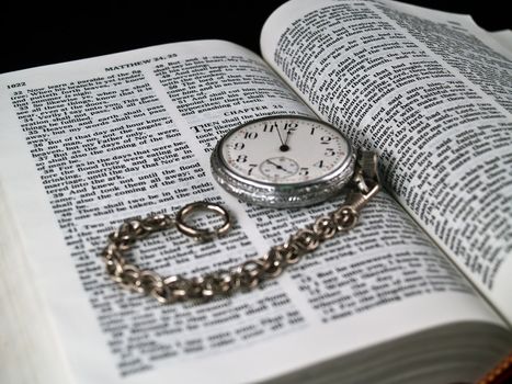 The Bible opened to Matthew 24: 36 with a Pocketwatch