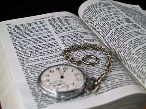 The Bible opened to Matthew 24: 36 with a Pocketwatch