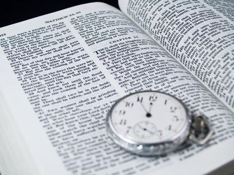 The Bible opened to Matthew 24: 36 with a Pocketwatch