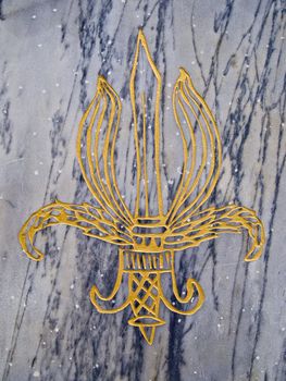 Golden trident on marble stone