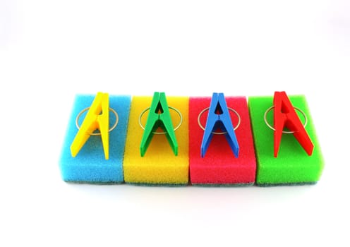 Color sponges and clothes-pegs over white