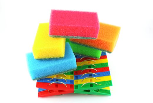 Color sponges and clothes-pegs over white