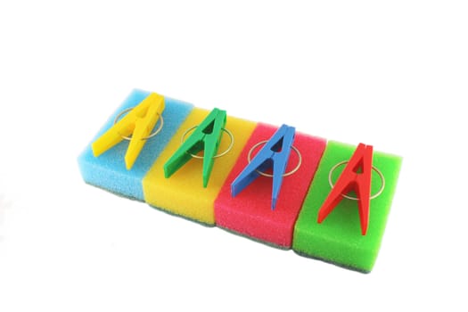 Color sponges and clothes-pegs over white