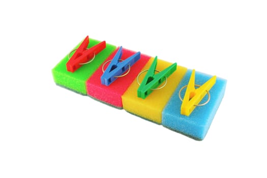 Color sponges and clothes-pegs over white