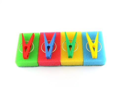 Color sponges and clothes-pegs over white