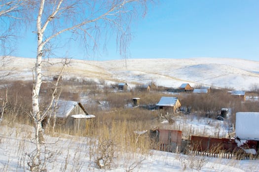 Houses in gardens under the hill, in winter.