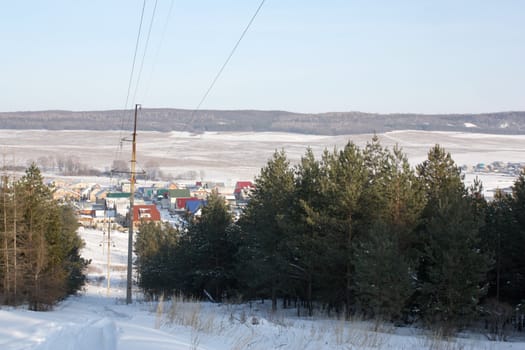 Power transmission line to village. Winter landscape