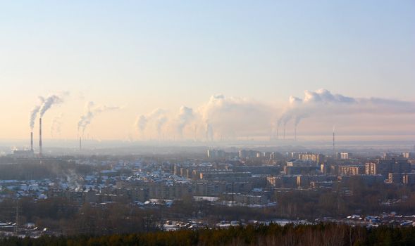 Chimney-stalks pollute atmosphere. Smoke on the city.