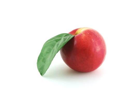 Ripe red apple with green leaf over white