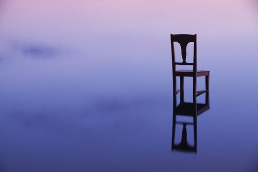 The old chair in the lake at sunset