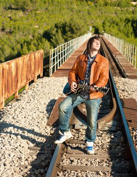 Guitarist performing on a railway bridge