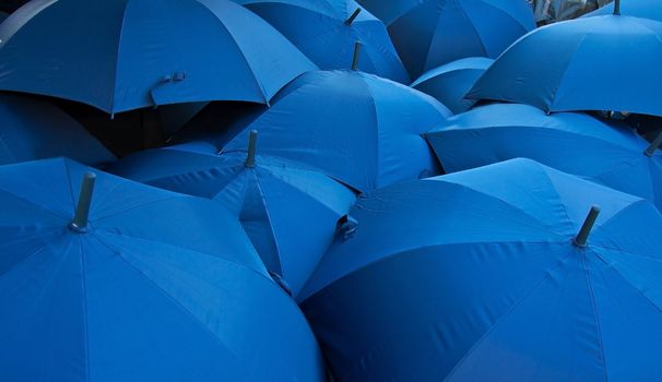 background of open blue umbrellas receding into distance