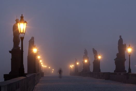 Famous Charles bridge on Vltava river in Prague in the mist