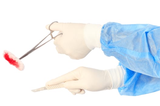 scalpel and clamp with swab in the hand of the surgeon during a surgery