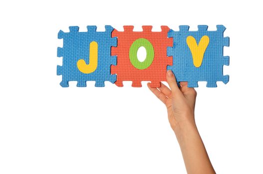teacher holding in the hand the amusing colored educational puzzles with the word joy