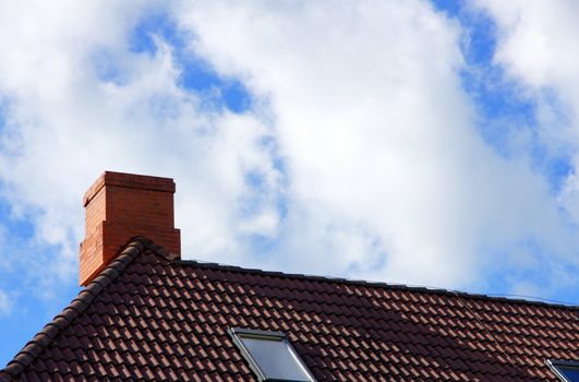 The roof and chimney with cloudy sky