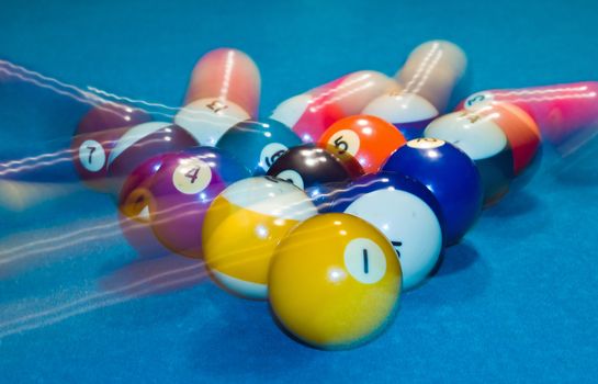Billiards balls with motion on a green pool table