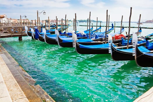 Blue and black gondola boats moored in Venice
