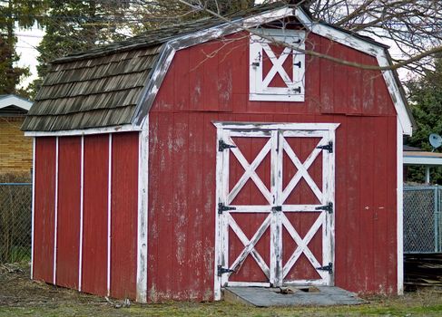 Weathered little red barn with white trim