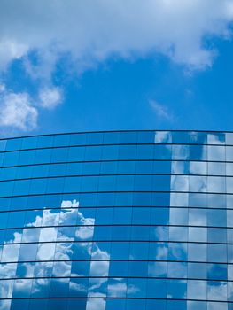 Clouds reflected in windows of modern office building 