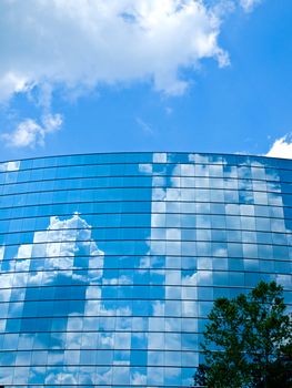 Clouds reflected in windows of modern office building 