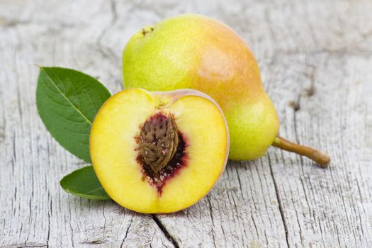 Fresh pear and peach on old wooden background