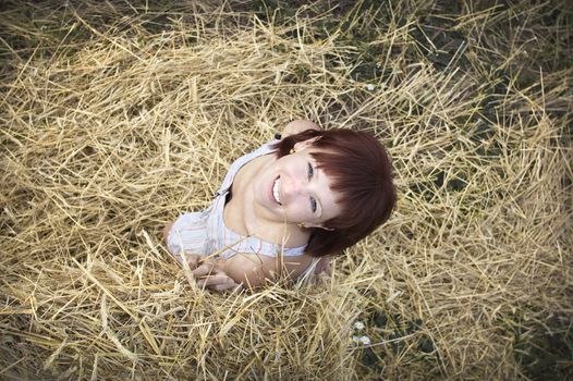 woman on a hay in a field outside the city