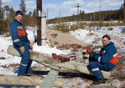 Young electricians on a break. Good mood. The end of winter