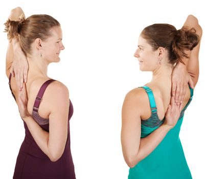 Two fit women stretching shoulders over white background