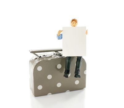 mans itting on suitcase holding white blanc paper for travel destination