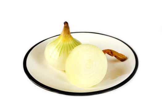 Unpeeled onions on plate against white background