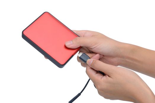 woman hand put USB cable into red external hard disk isolated on white background