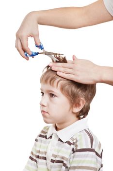Woman hand holding scissors cutting child hair