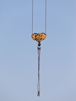 Building tower crane steel hook over blue sky