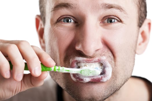 Dental hygiene - man holding toothbrush with toothpaste in hand and brushing teeth