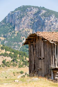 Old Turkish barn and scenic mountains in the background.