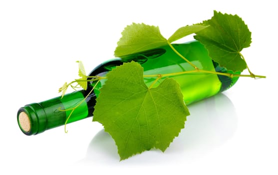 Bottle of wine with grape leaves isolated on white background 