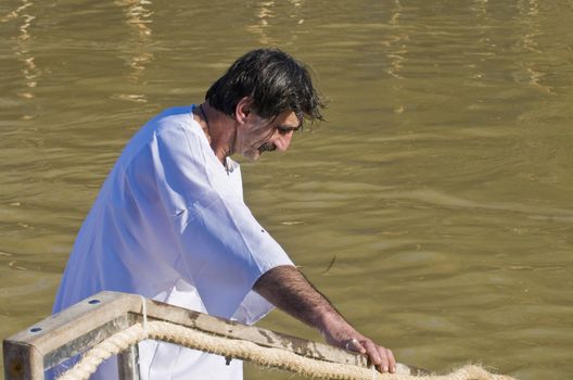 QASER EL YAHUD , ISRAEL - JAN 18 : Unidentified pilgrim man participates in the baptising ritual during the epiphany at Qaser el yahud , Israel in January 18 2012