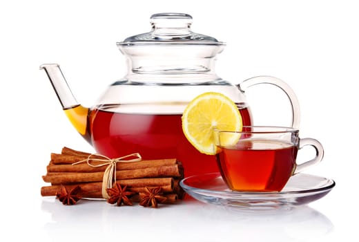 Teapot and tea in cup with spices and lemon isolated on white background 