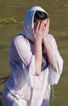QASER EL YAHUD , ISRAEL - JAN 18 : Unidentified pilgrim woman participates in the baptising ritual during the epiphany at Qaser el yahud , Israel in January 18 2012