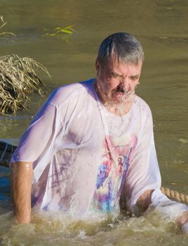 QASER EL YAHUD , ISRAEL - JAN 18 : Unidentified pilgrim man participates in the baptising ritual during the epiphany at Qaser el yahud , Israel in January 18 2012