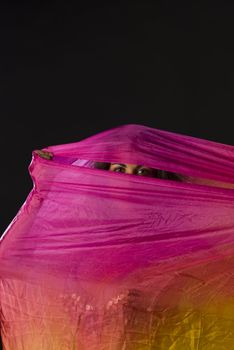 Mysterious eyes of a woman hiding behind a colorful headscarf