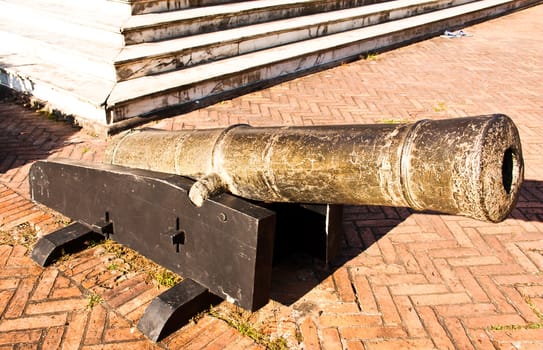 Ancient cannons placed on a cement floor.