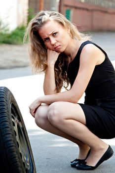 Beautiful young woman near the broken car