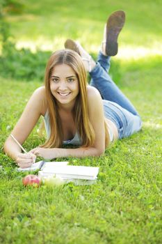 Teenage female student reading on Campus Lawn